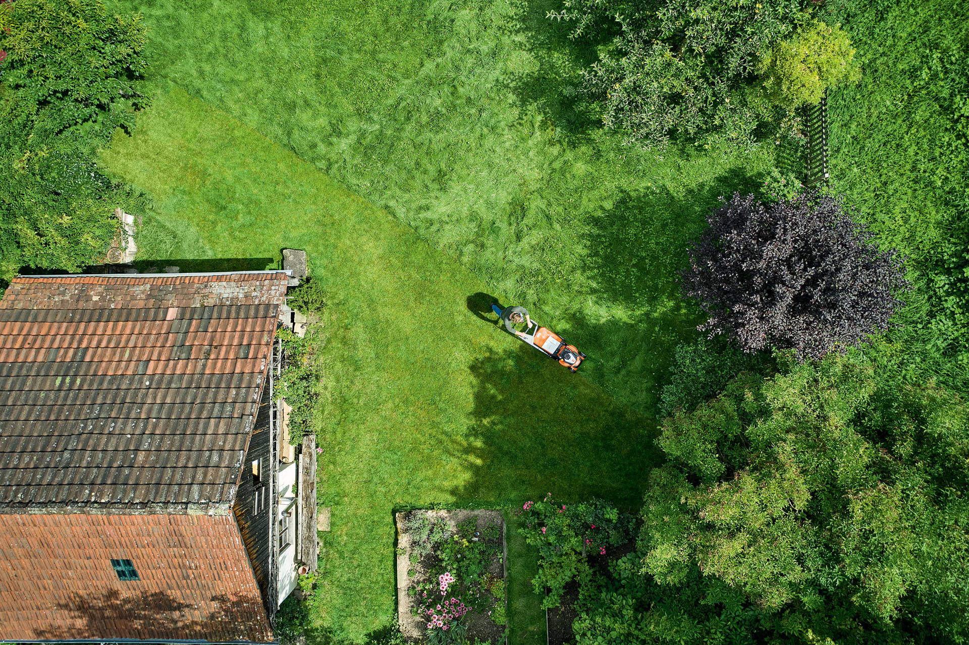 Aerial view of a person mowing a lawn with RM 650 petrol lawn mower